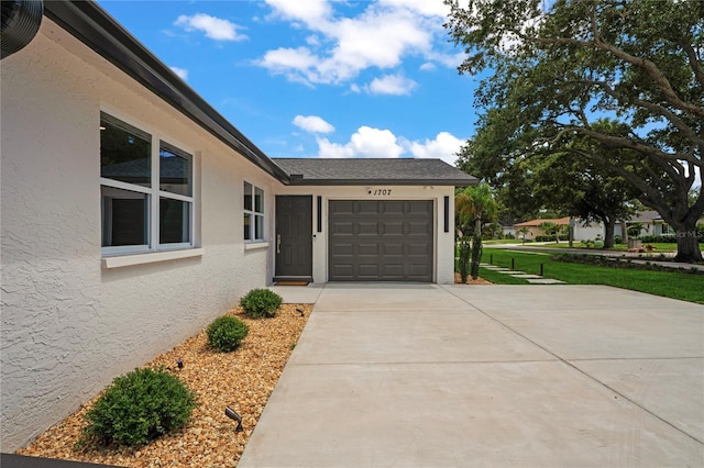 1707 Solon Ave, Dunedin, FL 34698 - view of side of home featuring stucco siding, an attached garage, and driveway
