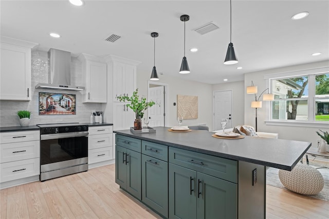 1707 Solon Ave, Dunedin, FL 34698 - kitchen featuring wall chimney range hood, stainless steel range with electric cooktop, white cabinets, dark countertops, and recessed lighting