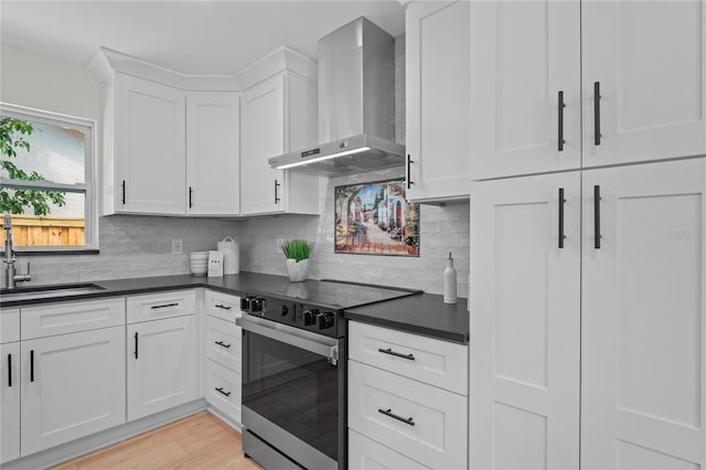 1707 Solon Ave, Dunedin, FL 34698 - kitchen featuring stainless steel electric range, wall chimney range hood, white cabinetry, dark countertops, and decorative backsplash