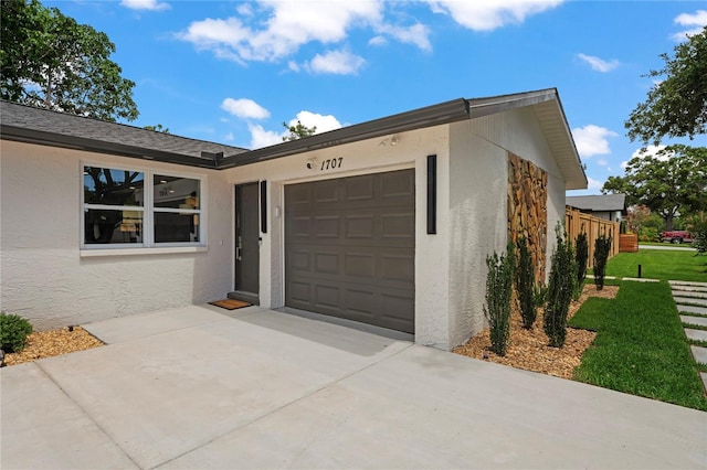 1707 Solon Ave, Dunedin, FL 34698 - view of front of home featuring a garage, driveway, stucco siding, and a front yard