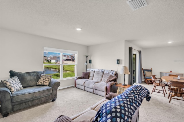7774 Sail Clover Ln, Zephyrhills, FL 33540 - carpeted living room featuring a textured ceiling, recessed lighting, and a water view