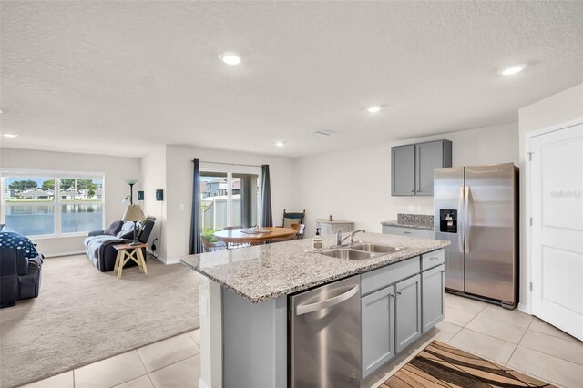 7774 Sail Clover Ln, Zephyrhills, FL 33540 - kitchen featuring stainless steel appliances, open floor plan, gray cabinets, light colored carpet, and a textured ceiling