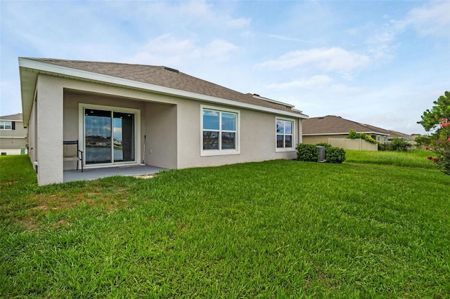 7774 Sail Clover Ln, Zephyrhills, FL 33540 - back of property with stucco siding, a lawn, and a patio