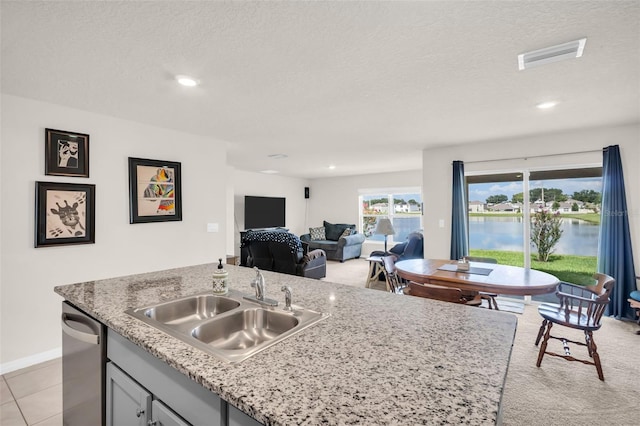 7774 Sail Clover Ln, Zephyrhills, FL 33540 - kitchen featuring stainless steel dishwasher, a textured ceiling, open floor plan, recessed lighting, and light stone countertops