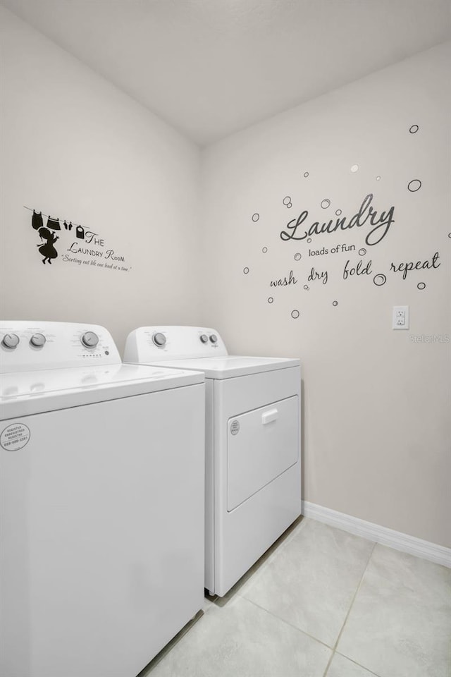 7774 Sail Clover Ln, Zephyrhills, FL 33540 - laundry room with washing machine and clothes dryer and light tile patterned floors