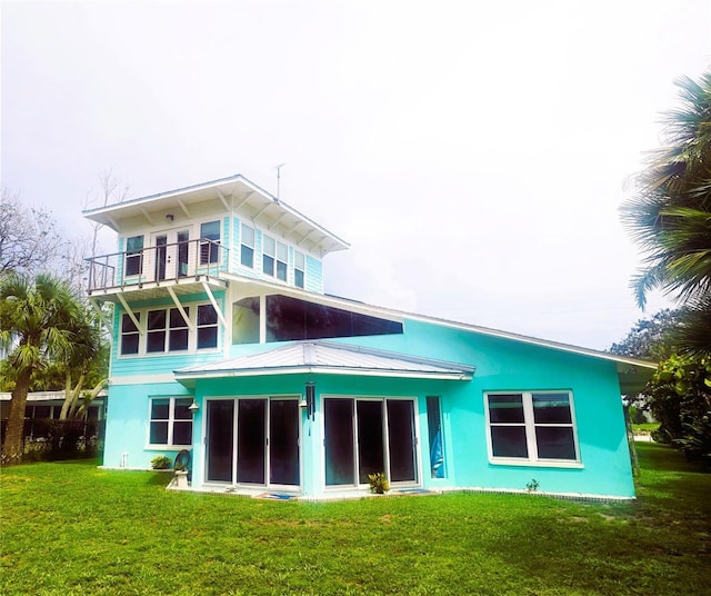 1626 Sea Breeze Dr, Tarpon Springs, FL 34689 - back of house with a balcony, a lawn, and stucco siding