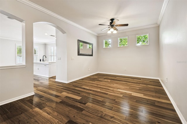 18203 Tivoli Ln, Lutz, FL 33558 - unfurnished room featuring plenty of natural light, ceiling fan, dark wood-type flooring, arched walkways, and crown molding