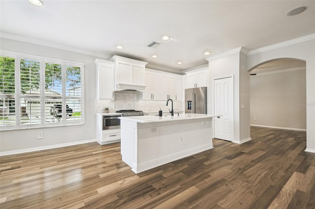 18203 Tivoli Ln, Lutz, FL 33558 - kitchen featuring high end fridge, arched walkways, tasteful backsplash, light countertops, and wood finished floors