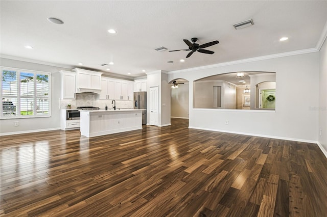 18203 Tivoli Ln, Lutz, FL 33558 - unfurnished living room featuring ceiling fan, crown molding, dark wood-style flooring, recessed lighting, and arched walkways