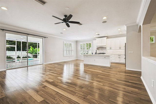 18203 Tivoli Ln, Lutz, FL 33558 - unfurnished living room with crown molding, ceiling fan, wood finished floors, and recessed lighting