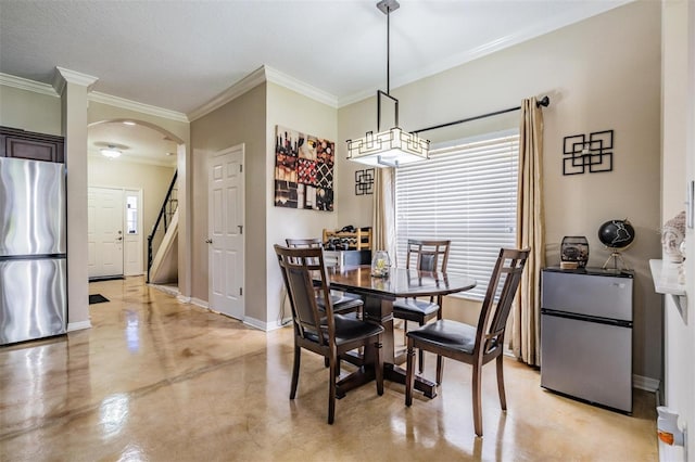 1031 Andrew Aviles Cir, Tampa, FL 33619 - dining space featuring arched walkways, concrete floors, crown molding, and stairs
