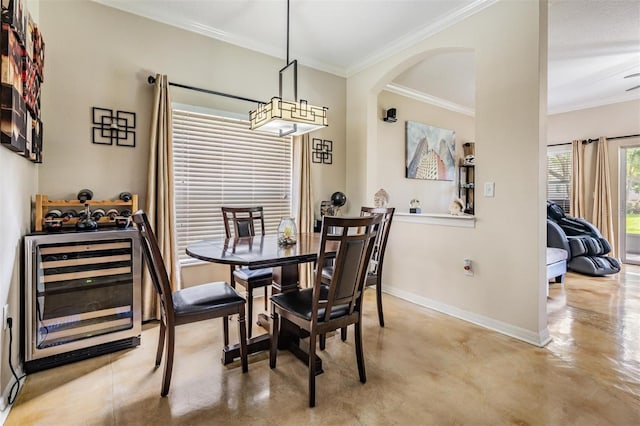 1031 Andrew Aviles Cir, Tampa, FL 33619 - dining space with wine cooler, ornamental molding, arched walkways, and concrete floors