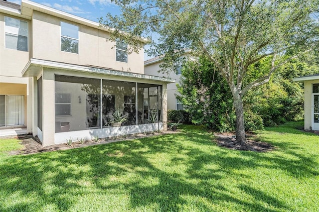 1031 Andrew Aviles Cir, Tampa, FL 33619 - back of house featuring a sunroom, a yard, and stucco siding