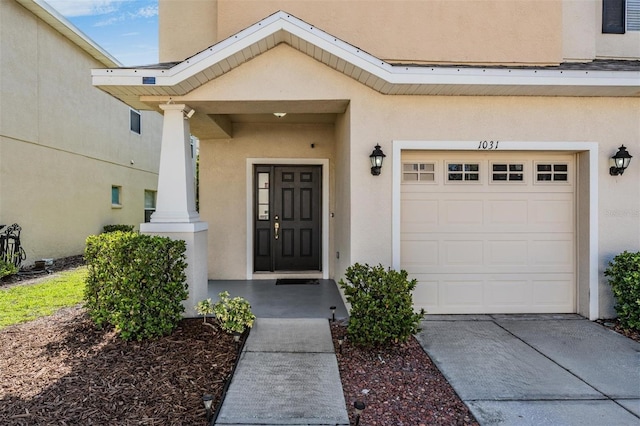 1031 Andrew Aviles Cir, Tampa, FL 33619 - entrance to property featuring stucco siding, a garage, and concrete driveway