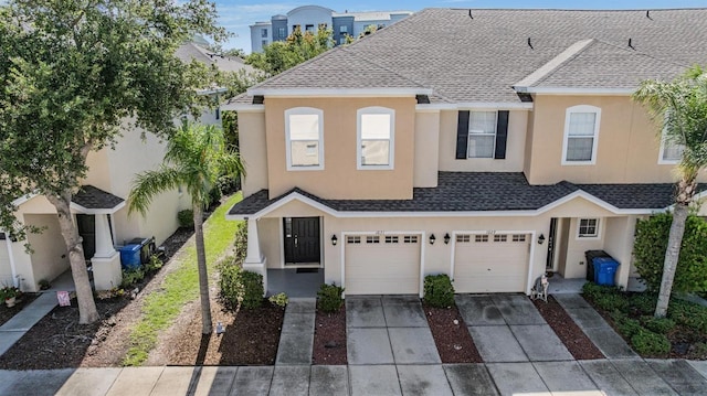 1031 Andrew Aviles Cir, Tampa, FL 33619 - view of property featuring a shingled roof, stucco siding, an attached garage, and concrete driveway
