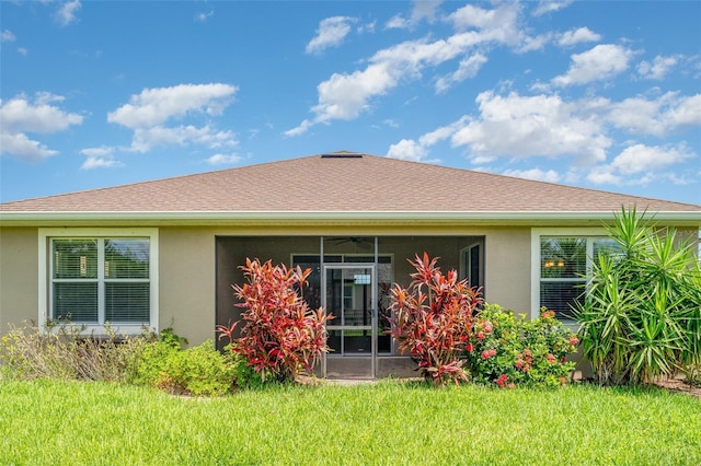 9067 39th Street Cir E, Parrish, FL 34219 - back of property with stucco siding, a sunroom, a yard, and ceiling fan
