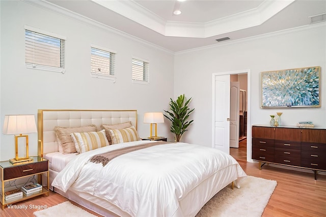 9067 39th Street Cir E, Parrish, FL 34219 - bedroom featuring a tray ceiling, light wood-style floors, and crown molding