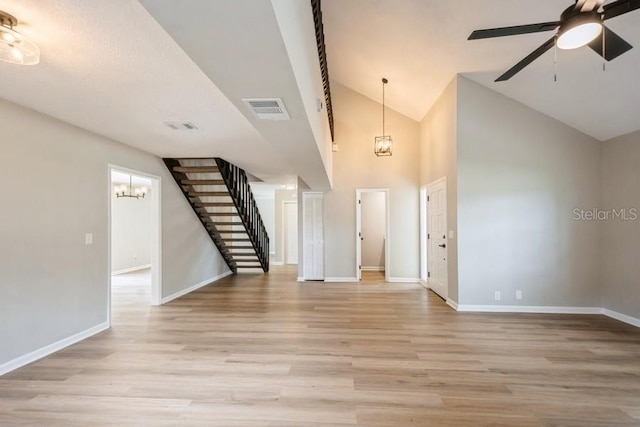 14909 Oldgate Pl, Tampa, FL 33624 - entryway featuring stairway, light wood-style flooring, a chandelier, a ceiling fan, and high vaulted ceiling