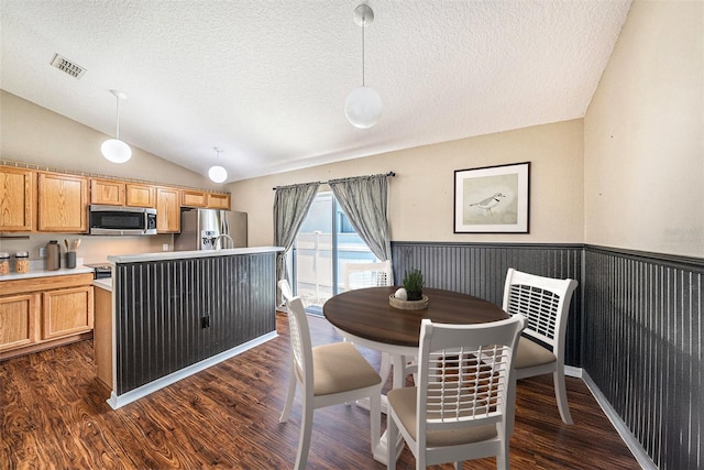 3443 Fyfield Ct, Land O Lakes, FL 34638 - dining space featuring lofted ceiling, a textured ceiling, a wainscoted wall, and dark wood finished floors