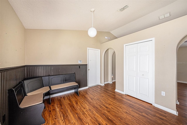 3443 Fyfield Ct, Land O Lakes, FL 34638 - sitting room with arched walkways, wood finished floors, vaulted ceiling, and wainscoting