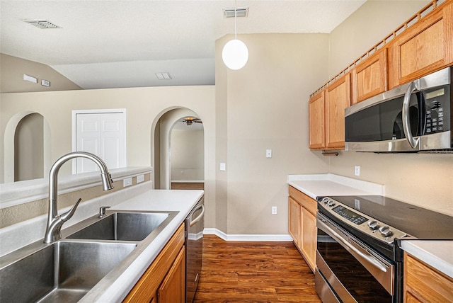 3443 Fyfield Ct, Land O Lakes, FL 34638 - kitchen with appliances with stainless steel finishes, dark wood-type flooring, arched walkways, decorative light fixtures, and light countertops