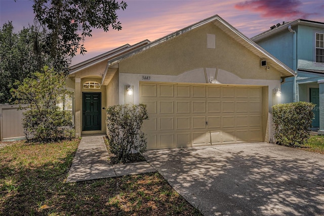 3443 Fyfield Ct, Land O Lakes, FL 34638 - view of front of house with stucco siding, a garage, and concrete driveway