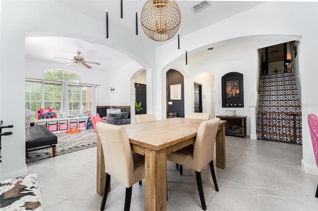 8050 Diablo Ct, Trinity, FL 34655 - dining space featuring arched walkways, a ceiling fan, light tile patterned floors, and stairs