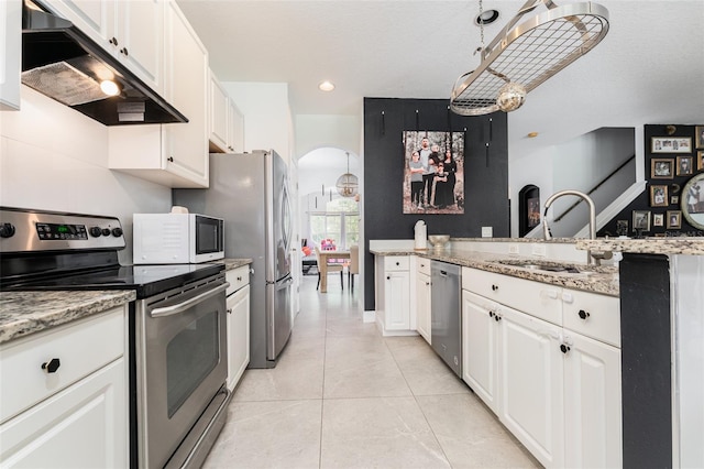 8050 Diablo Ct, Trinity, FL 34655 - kitchen featuring appliances with stainless steel finishes, under cabinet range hood, white cabinets, light tile patterned floors, and recessed lighting
