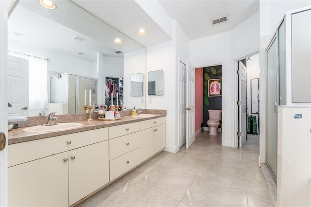8050 Diablo Ct, Trinity, FL 34655 - bathroom featuring double vanity, a shower stall, recessed lighting, a walk in closet, and tile patterned flooring