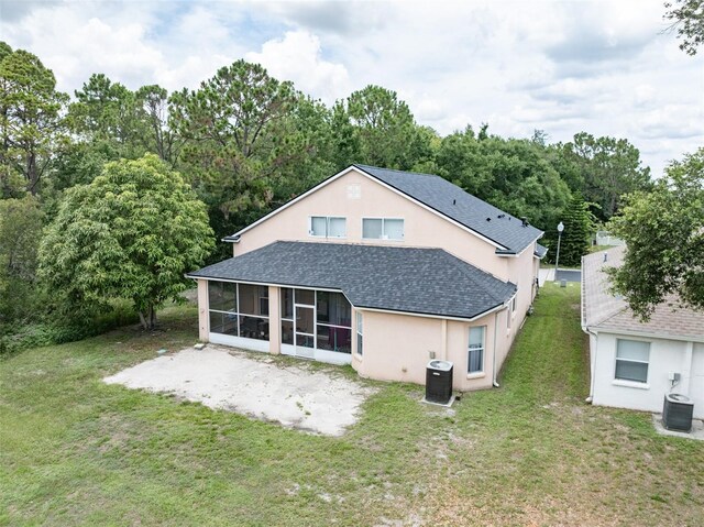 8050 Diablo Ct, Trinity, FL 34655 - back of property featuring a sunroom, a shingled roof, stucco siding, and a lawn