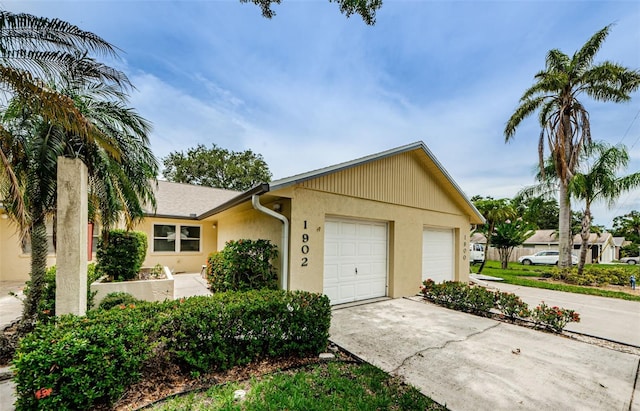 1902 Elaine Dr, Clearwater, FL 33760 - ranch-style home featuring concrete driveway, an attached garage, and stucco siding