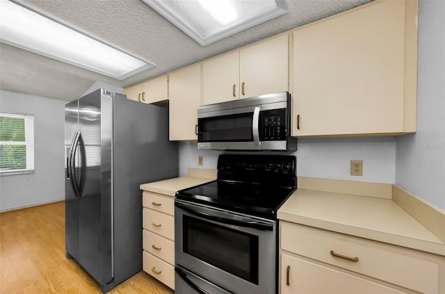 1902 Elaine Dr, Clearwater, FL 33760 - kitchen featuring appliances with stainless steel finishes, cream cabinets, light countertops, and light wood finished floors
