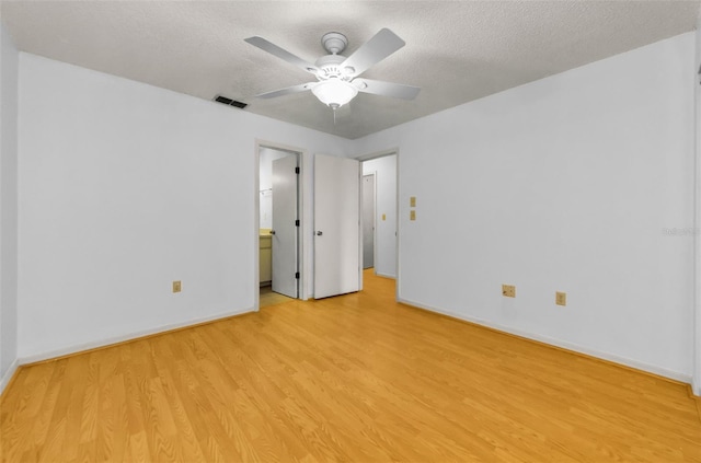 1902 Elaine Dr, Clearwater, FL 33760 - unfurnished bedroom with light wood-style floors, a textured ceiling, ceiling fan, and ensuite bath