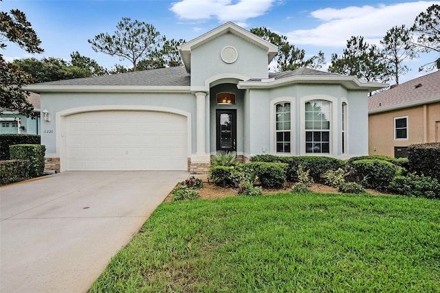 11220 Paradise Pointe Way, New Port Richey, FL 34654 - view of front facade with a garage, stucco siding, and concrete driveway