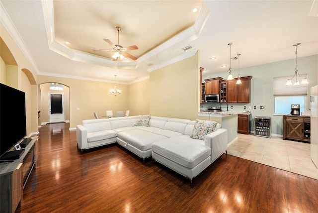 11220 Paradise Pointe Way, New Port Richey, FL 34654 - living room with light wood-style floors, ceiling fan, a raised ceiling, ornamental molding, and arched walkways