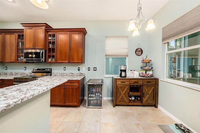 11220 Paradise Pointe Way, New Port Richey, FL 34654 - kitchen featuring appliances with stainless steel finishes, light stone counters, light tile patterned floors, glass insert cabinets, and decorative light fixtures