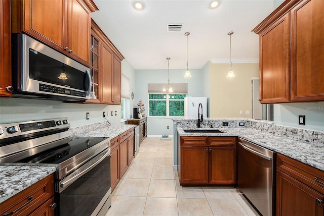 11220 Paradise Pointe Way, New Port Richey, FL 34654 - kitchen with stainless steel appliances, a peninsula, light stone counters, brown cabinetry, and ornamental molding