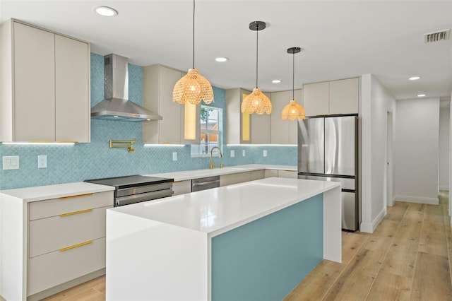 4704 W Fairview Hts, Tampa, FL 33616 - kitchen with wall chimney exhaust hood, appliances with stainless steel finishes, light wood-type flooring, decorative backsplash, and light countertops