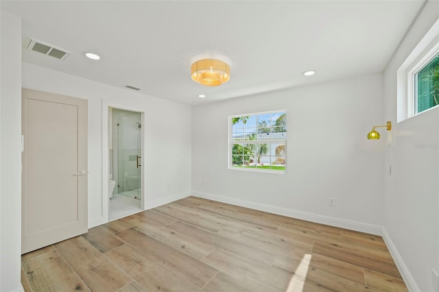 4704 W Fairview Hts, Tampa, FL 33616 - unfurnished bedroom with multiple windows, light wood finished floors, recessed lighting, and ensuite bath