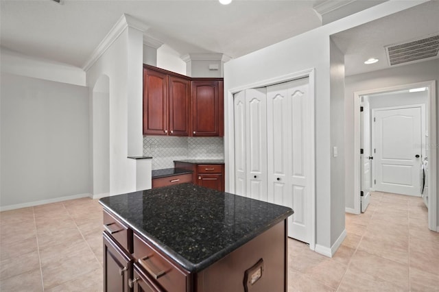 10101 Paddock Oaks Dr, Riverview, FL 33569 - kitchen with tasteful backsplash, dark stone countertops, light tile patterned flooring, arched walkways, and recessed lighting