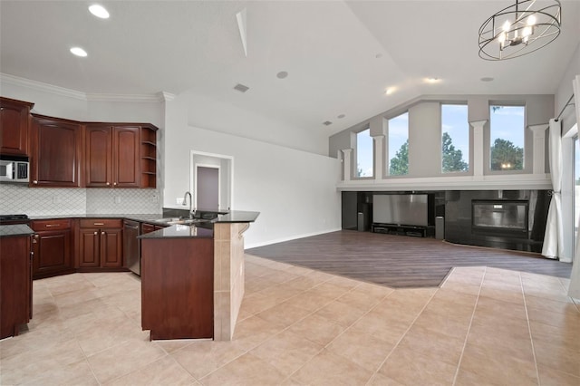 10101 Paddock Oaks Dr, Riverview, FL 33569 - kitchen with a peninsula, appliances with stainless steel finishes, dark countertops, light tile patterned floors, and lofted ceiling