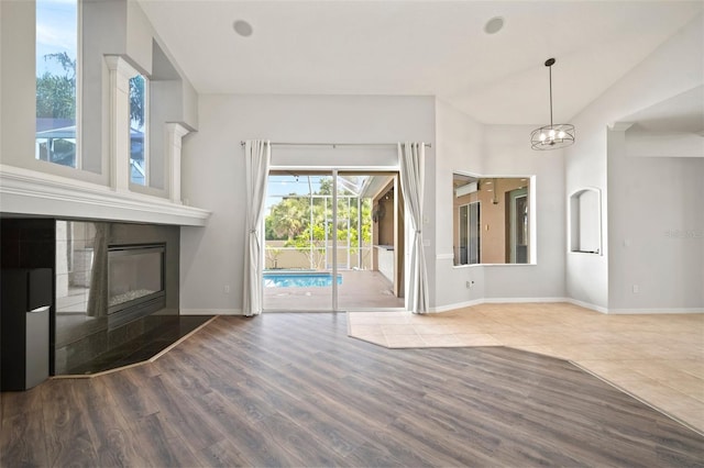 10101 Paddock Oaks Dr, Riverview, FL 33569 - unfurnished living room with wood finished floors, a tile fireplace, and a chandelier