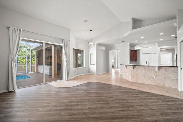 10101 Paddock Oaks Dr, Riverview, FL 33569 - unfurnished living room featuring arched walkways, wood finished floors, lofted ceiling, and recessed lighting