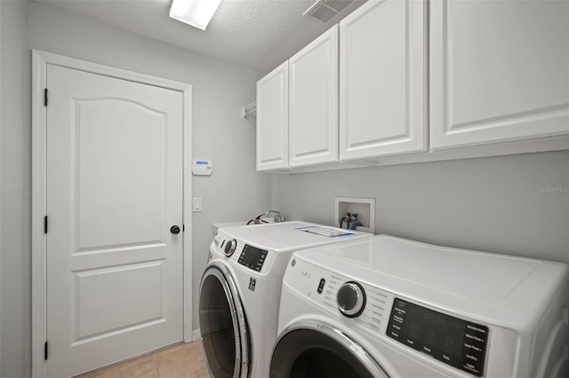 10101 Paddock Oaks Dr, Riverview, FL 33569 - laundry room featuring cabinet space, washer and dryer, light tile patterned floors, and a textured ceiling