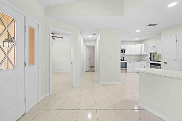 2141 Coachman Rd, Spring Hill, FL 34608 - kitchen featuring stainless steel appliances, white cabinetry, light countertops, recessed lighting, and light tile patterned floors