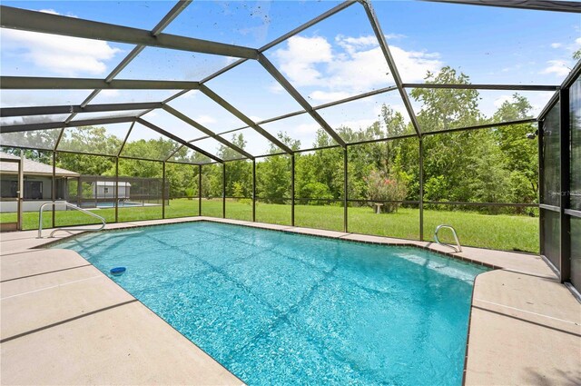 2141 Coachman Rd, Spring Hill, FL 34608 - outdoor pool with a lawn, a patio, and glass enclosure