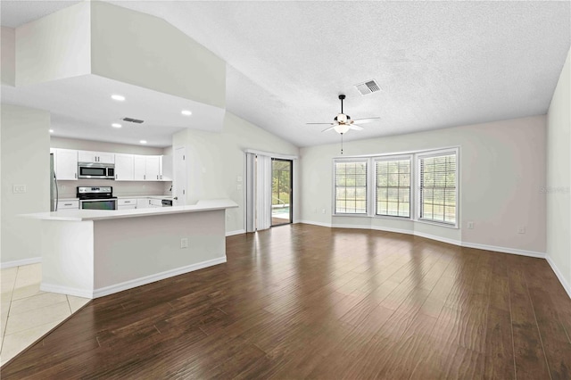 2141 Coachman Rd, Spring Hill, FL 34608 - unfurnished living room featuring a ceiling fan, vaulted ceiling, wood finished floors, recessed lighting, and a textured ceiling