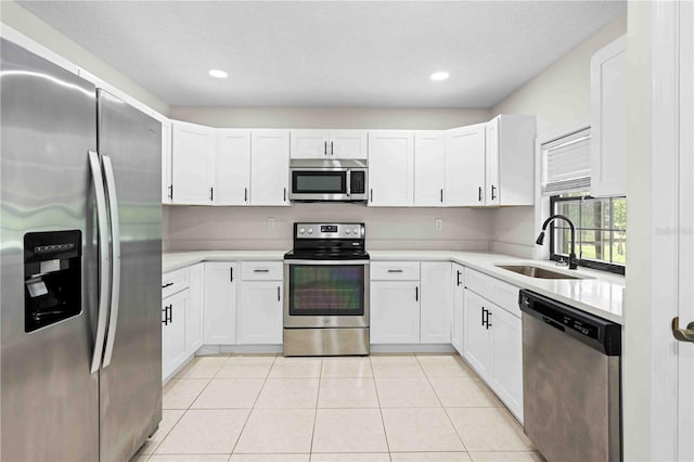 2141 Coachman Rd, Spring Hill, FL 34608 - kitchen with stainless steel appliances, light countertops, white cabinets, light tile patterned floors, and recessed lighting