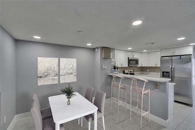 6601 121st Ave Unit I, Largo, FL 33773 - dining space with recessed lighting, light tile patterned floors, and a textured ceiling