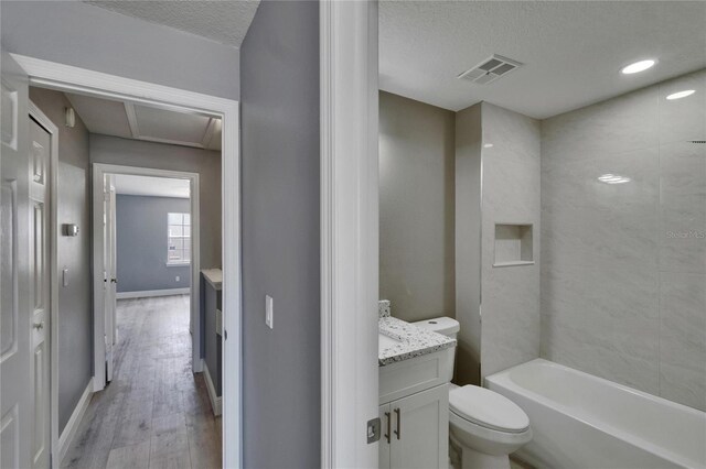 6601 121st Ave Unit I, Largo, FL 33773 - full bath with vanity, wood finished floors, a textured ceiling, and bathing tub / shower combination